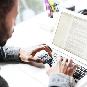 Mann arbeitet mit Word am Laptop