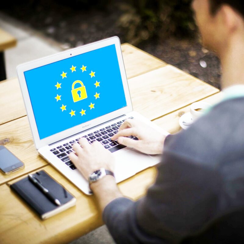 Mann arbeitet am Laptop mit Datenschutz-Symbol